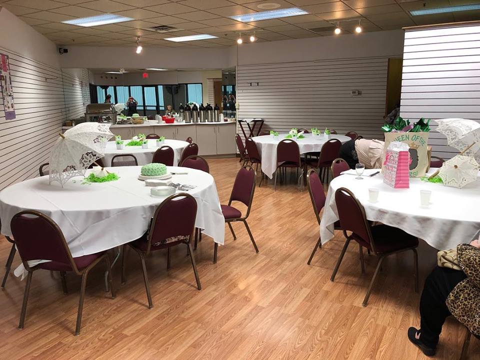 Room setup for private event party Tables have green decorations and gift bags.